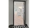 Inviting entryway with black and white tiled floors and a view of the modern white kitchen at 400 E Colonial Dr # 402, Orlando, FL 32803