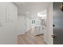 Bright entryway with wood-look floors leading to a stylish, all-white kitchen and living area at 400 E Colonial Dr # 402, Orlando, FL 32803