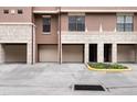 Street view of several townhome garages, two-car tandem style, with stone facade at 6107 Metrowest Blvd # 104, Orlando, FL 32835