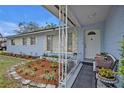 Inviting front porch with a landscaped flower bed, bench seating, white trim, and a decorative front door at 806 Bear Lake Rd, Apopka, FL 32703