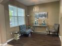 Cozy living area with stylish decor, featuring a modern light fixture, elegant furniture, and a bright window at 8417 Leeland Archer Blvd, Orlando, FL 32836