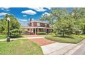 Inviting home featuring a brick driveway, covered parking, and a charming front porch at 900 S Palmetto Ave, Sanford, FL 32771