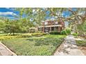 Beautiful property featuring a lush green lawn, mature trees, and charming exterior details at 900 S Palmetto Ave, Sanford, FL 32771
