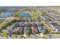 Aerial view of community featuring a lake, fountain, playground and pool; property highlighted with red pin at 9038 Sunshine Ridge Loop, Kissimmee, FL 34747