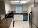 Efficient kitchen features white cabinets, stainless steel refrigerator, and modern appliances at 9926 Turf Way # 8, Orlando, FL 32837