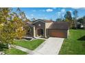 Aerial view of a home with a well-maintained lawn and landscaping in a peaceful neighborhood at 997 La Mirada Ct, Kissimmee, FL 34744