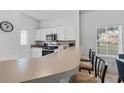 Bright kitchen with breakfast bar, white cabinets, and modern appliances at 1084 Park Ridge Cir, Kissimmee, FL 34746