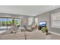 Spacious living room featuring neutral tones, tile flooring, modern decor and access to outdoor area at 13125 Alderley Dr, Orlando, FL 32832