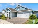 Corner-lot home with two-car garage, brick driveway, and landscaped yard at 14925 Lebeau Loop, Winter Garden, FL 34787