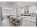 Modern, open kitchen with stainless steel appliances, a kitchen island with seating, and a view of the dining area at 14925 Lebeau Loop, Winter Garden, FL 34787