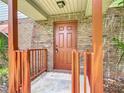 Inviting front door with brick surround and a covered porch with wood railing at 1591 Revere Ln, Daytona Beach, FL 32117
