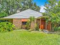A charming home with brick and siding, complemented by lush landscaping and a welcoming entrance at 1591 Revere Ln, Daytona Beach, FL 32117