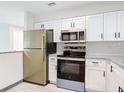 Modern kitchen featuring stainless steel appliances, white cabinets, and stylish countertops at 1591 Revere Ln, Daytona Beach, FL 32117
