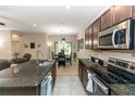Modern kitchen featuring granite countertops, stainless steel appliances, and an adjacent dining area at 20723 Macon Pkwy, Orlando, FL 32833