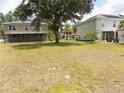 Large grassy backyard with mature trees between two houses at 2818 Sheila Dr, Apopka, FL 32712