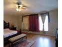 Spacious main bedroom featuring gleaming hardwood floors and decorative window coverings at 2818 Sheila Dr, Apopka, FL 32712