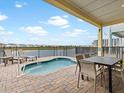 Outdoor patio featuring a small pool, table and chairs with a beautiful view of the community and the sky at 3036 Parrot Head Pl, Kissimmee, FL 34747