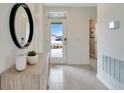 Bright foyer featuring tiled floors, decorative mirror, wooden console table, and a clear view of the front yard at 3438 Briarwood Grove Dr, Ocoee, FL 34761