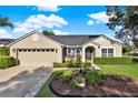 Inviting home exterior featuring manicured landscaping, a well-kept lawn, and an attached garage with driveway at 3499 Woodley Park Pl, Oviedo, FL 32765