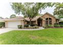 Inviting brick home features a well-manicured lawn, walkway, and attached two-car garage at 356 Remington Dr, Oviedo, FL 32765