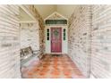 Charming covered porch with brick walls, decorative tile flooring, and a welcoming front door at 356 Remington Dr, Oviedo, FL 32765