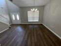 Open-concept living space featuring dark wood-look flooring, white trim and staircase, and a bright front entrance at 3707 Andover Cay Blvd, Orlando, FL 32825