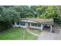 Aerial view of a white single-story home with blue shutters and a brick driveway and carport at 409 E Gulley Ave, Oakland, FL 34760