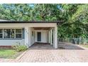 View of the home's carport with brick pavers, white pillars, and a fan at 409 E Gulley Ave, Oakland, FL 34760