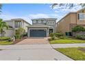 Charming home with a two-car garage and a lovely brick paved driveway, surrounded by mature landscaping at 441 Novi Path, Kissimmee, FL 34747
