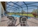Inviting screened-in pool area with striped lounge chairs and beautiful backyard views at 446 Summer Place Loop, Clermont, FL 34714