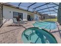 Relaxing pool and spa featuring a brick patio and a screened-in enclosure at 446 Summer Place Loop, Clermont, FL 34714