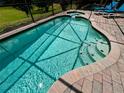 Inviting screened-in pool with a spa and brick paver decking; perfect for relaxation and enjoyment at 446 Summer Place Loop, Clermont, FL 34714