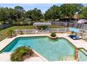 An aerial view of an inviting pool with a pergola seating area, lounge chairs, and a spa at 4674 Hall Rd, Orlando, FL 32817