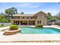 Resort-style backyard oasis with pool, covered patio, and a second-story balcony overlooking the backyard at 4674 Hall Rd, Orlando, FL 32817