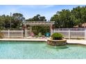 Beautiful in-ground pool with a fountain feature and pergola seating area at 4674 Hall Rd, Orlando, FL 32817