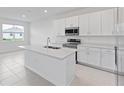 Bright kitchen boasts white cabinets, stainless steel appliances, and ample counter space at 499 Silver Palm Dr, Haines City, FL 33844