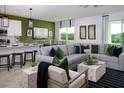 Open-concept living room with a large sofa, a dining area, and a modern kitchen, perfect for entertaining guests at 499 Silver Palm Dr, Haines City, FL 33844