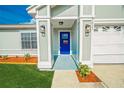 Inviting front entryway featuring a bright blue door and stylish outdoor lighting at 5037 Water Wheel Ct, Ocoee, FL 34761