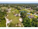 Overhead view of a home near a lush golf course with mature trees, and a community pond at 513 N Pine Meadow Dr, Debary, FL 32713