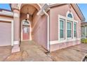 Close up of home's entry featuring a covered porch, stone pillars, and decorative front door with sidelights at 5273 Sunset Canyon Dr, Kissimmee, FL 34758