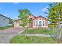 Inviting single-level home featuring a manicured lawn and a cozy front porch in a suburban neighborhood at 5273 Sunset Canyon Dr, Kissimmee, FL 34758