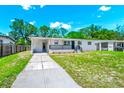 Inviting one-story home featuring a black metal railing and a well-manicured lawn at 5513 Riordan Way, Orlando, FL 32808