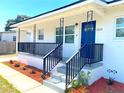 Welcoming front porch with decorative black railings and a bright blue door at 5513 Riordan Way, Orlando, FL 32808