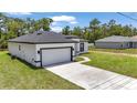 Side view of a modern white house with a two-car garage, long driveway, and manicured lawn at 586 Marion Oaks Trl, Ocala, FL 34473