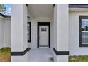 Close-up of the front door framed by columns with black accents, adding a touch of modern elegance to the entryway at 586 Marion Oaks Trl, Ocala, FL 34473