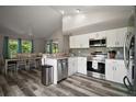 Modern kitchen with white cabinets, stainless steel appliances, granite countertops, and views of the attached dining area at 612 Heron Bay Dr, Orlando, FL 32825