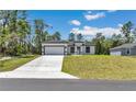 A charming single-story home boasting a well-manicured lawn and a modern white exterior with black trim at 6691 Sw 151Sr Loop, Ocala, FL 34473