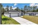 Attractive single-story home with an attached garage, white exterior and freshly installed lawn at 6691 Sw 151Sr Loop, Ocala, FL 34473