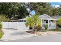 Charming home featuring a blue door, white picket fence, well-manicured landscaping, and a private, fenced driveway at 674 Douglas Ave, Winter Park, FL 32789