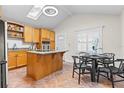 Kitchen with granite island, vaulted ceiling, stainless steel appliances, and eating area at 674 Douglas Ave, Winter Park, FL 32789
